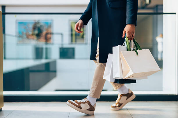 istock Man Carrying Shopping Bags in Modern Mall Environment 2208552091