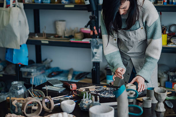 istock Ceramist sculpting small clay pots in her workshop 2208552936