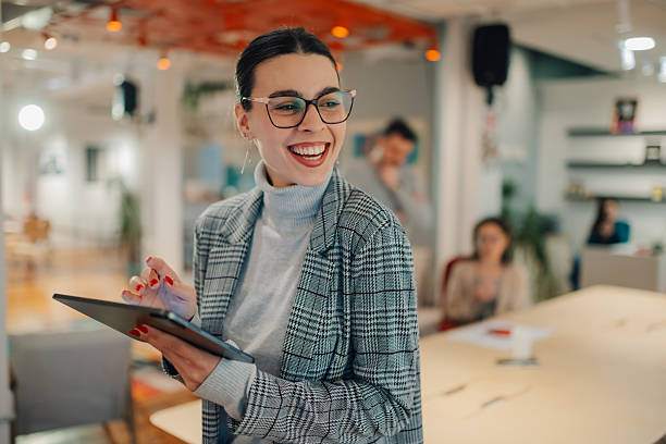 istock Young businesswoman smiling and using digital tablet in modern office 2208554315