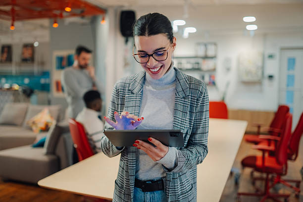 istock Young businesswoman smiling and using digital tablet in modern office 2208554321