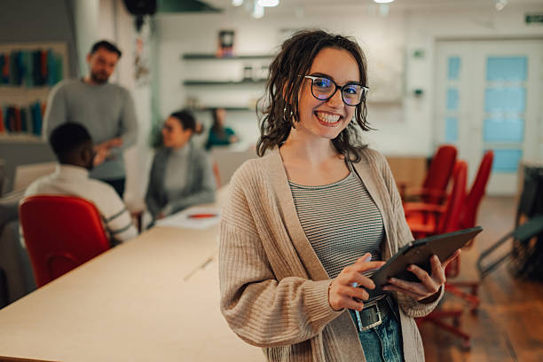 istock Young businesswoman smiling and using digital tablet in modern office 2208554334