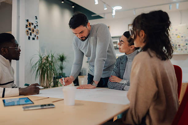 istock Team of young professionals brainstorming on a project in modern office 2208554349