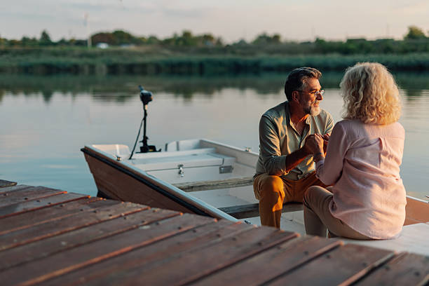 istock Senior couple holding hands while relaxing on boat at sunset 2208555915