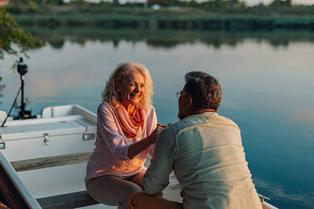 istock Happy senior couple holding hands while enjoying a romantic sunset boat trip 2208555918