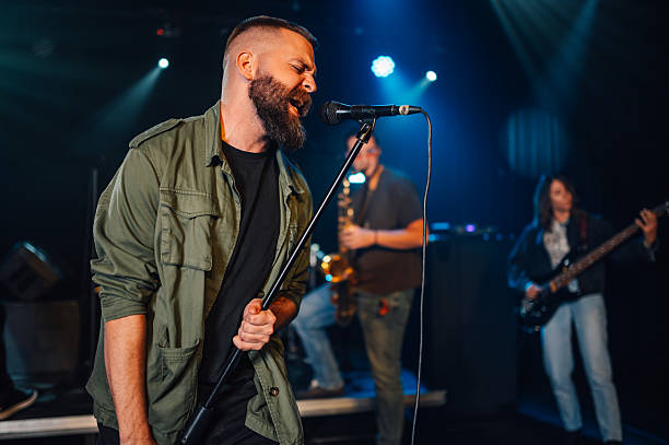 istock Singer performing with passion on stage with band 2208556371