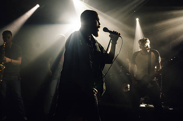 istock Singer performing with band on stage under stage lights 2208556856