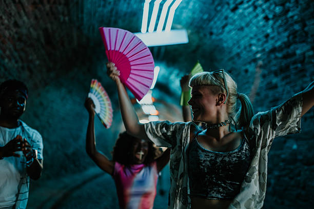 istock Young people dancing with fans in a tunnel at night 2208556935