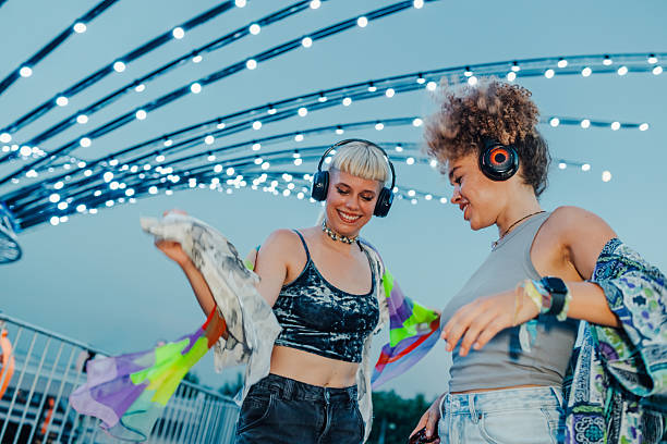 istock Two young women dancing at music festival under string lights 2208556957