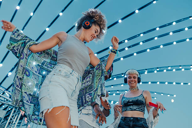 Young people dancing at silent disco with headphones