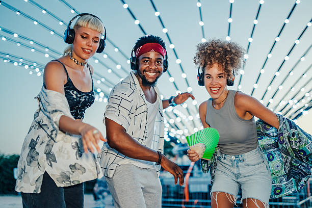istock Young people dancing at silent disco, wearing headphones and smiling 2208556964