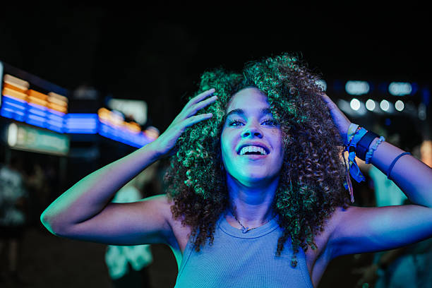 istock Young woman dancing with neon lights at night 2208557047