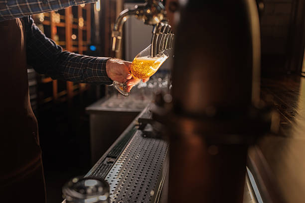 istock Bartender pouring a fresh beer from the tap in a pub 2208559780