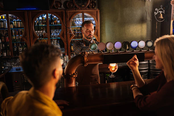 istock Bartender pouring beer for friends in a pub 2208559798