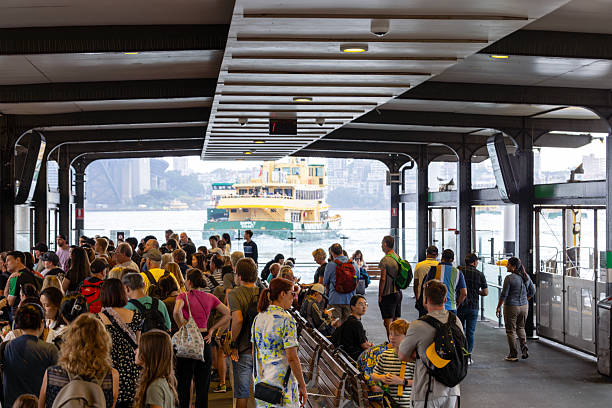 Sydney, Australia - March23, 2025: Circular Quay ferry wharf with waiting passengers for ferry arrival\nCircular Quay ferry wharf is a complex of wharves at Circular Quay, on Sydney Cove, that serves as the hub for the Sydney Harbour ferry network.