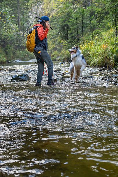 istock Joyful Young Woman and Playful Dog in Serene River Setting 2208572349