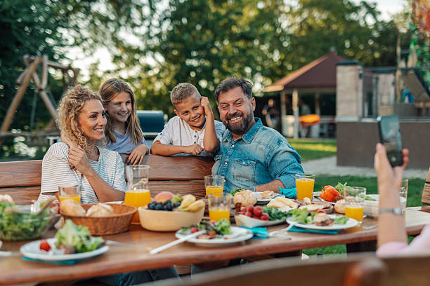 istock Happy family posing for a photo during a backyard barbecue 2208573882