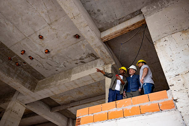istock Group of building contractors looking at a construction site and pointing away 2208577504