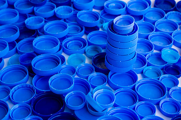 Close up taken of many blue,plastic caps of natural spring water bottle on the white surface,background