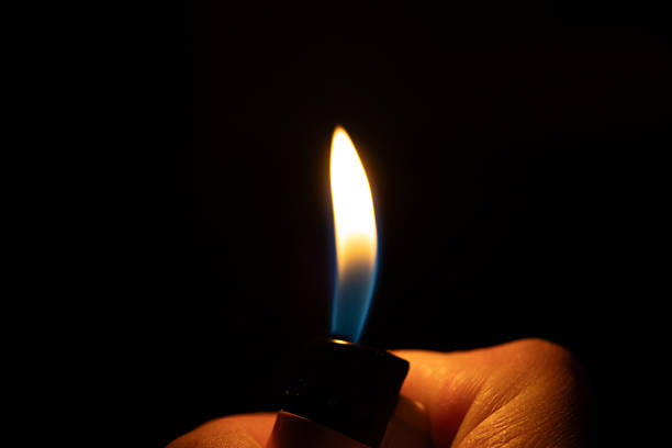 istock A flaming lighter in hand amidst the darkness 2208588720