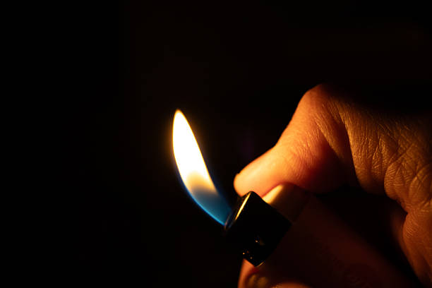 istock A flaming lighter in hand amidst the darkness 2208588797
