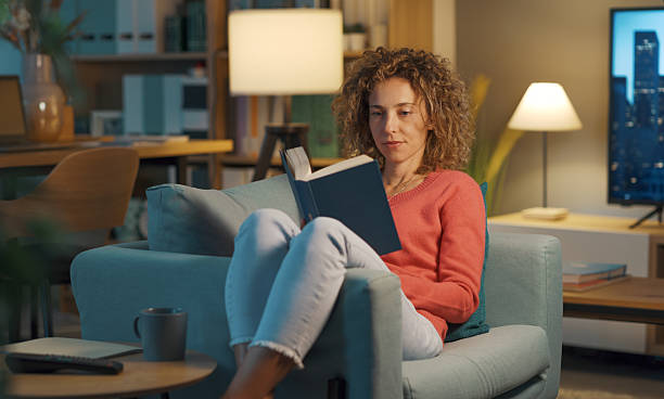 istock Relaxed woman reading a book at home 2208594195