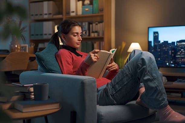 istock Happy girl relaxing at home and reading a book 2208594264
