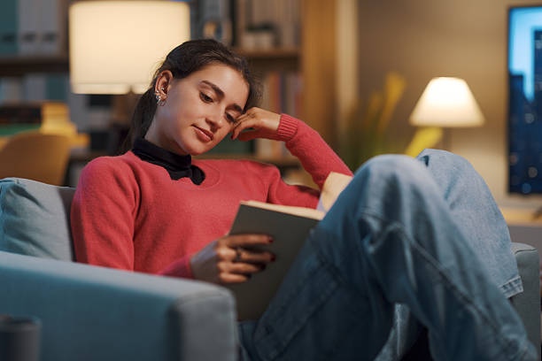 istock Happy girl relaxing at home and reading a book 2208594296