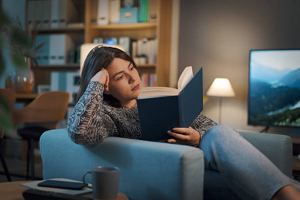 istock Relaxed woman reading a book at home 2208594745