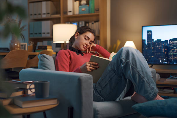 istock Happy girl relaxing at home and reading a book 2208594781