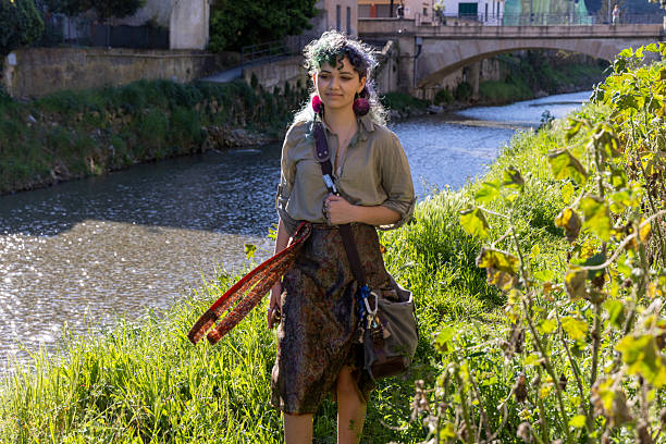 Young, mixed race, generation z woman walks along riverbank in springtime, Liguria