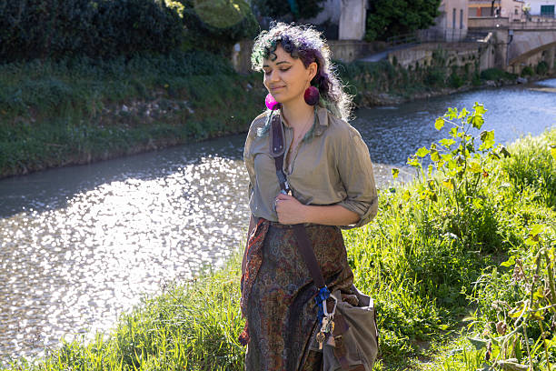 Young, mixed race, generation z woman walks along riverbank in springtime, Liguria