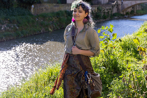 Young, mixed race, generation z woman walks along riverbank in springtime, Liguria