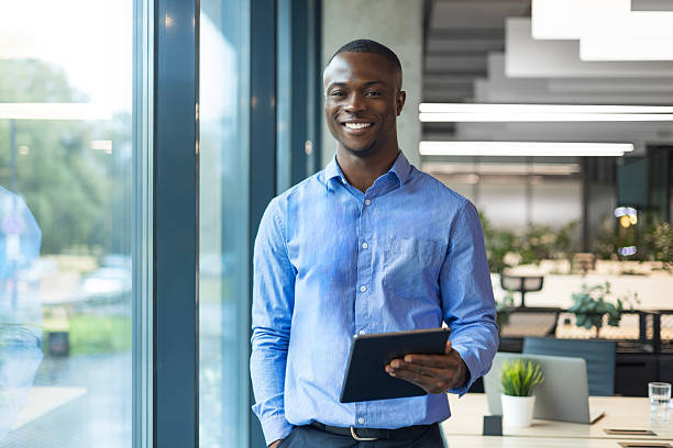 istock Smiling busy african businessman manager using tablet computer standing in office 2208613814