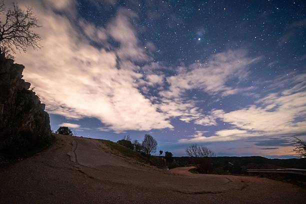 istock Serene night landscape with starry sky and winding road. 2208614577