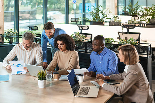 istock Successful businesspeople working in a coworking space working with laptop discussing strategy and business plan in modern office. 2208617067