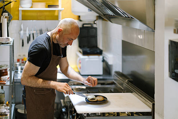istock Chef finishing gourmet burger in restaurant kitchen 2208619862