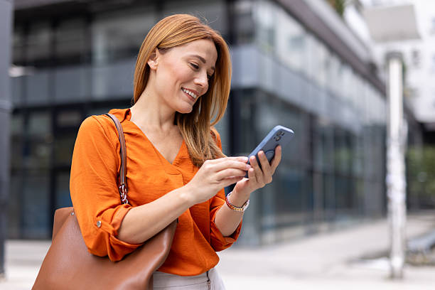 istock Smiling businesswoman using smartphone in urban setting 2208620538