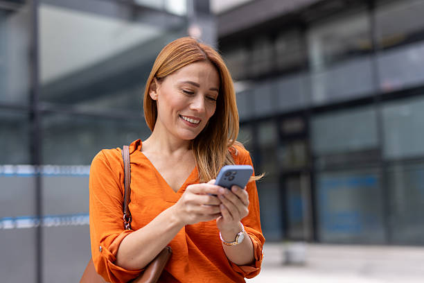 istock Smiling businesswoman using smartphone in urban setting 2208620696