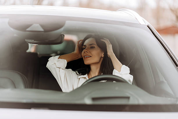 istock Businesswoman adjusting hair while driving modern car 2208621103