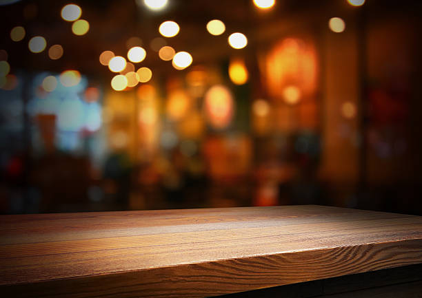 istock wooden table top on blur light golden 2208623349