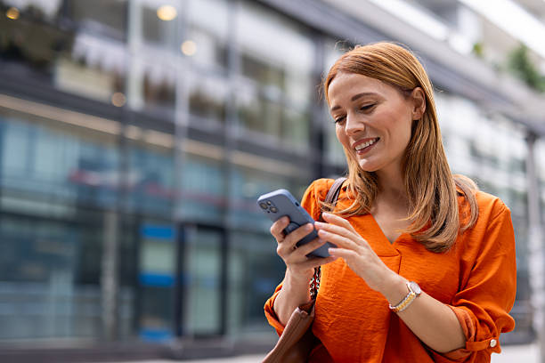 istock Smiling businesswoman using smartphone in urban setting 2208625101