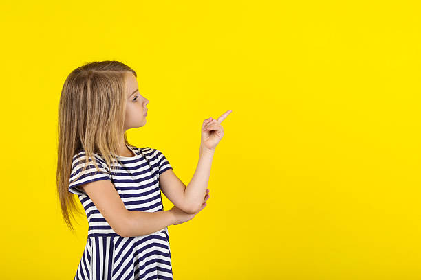 istock Beautiful little girl on yellow background 2208625659
