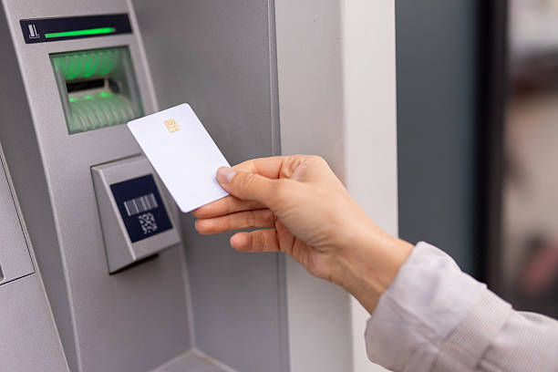 istock Woman withdrawing cash using credit card at atm 2208626905