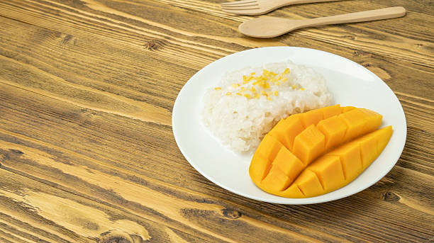 istock Sticky rice and ripe mango (Thai dessert) on a wooden table. 2208627463