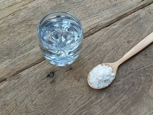 istock Salt water solution in glass on wooden table background 2208627637