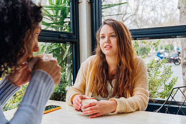 istock Mother and daughter sharing laughter, bonding over steaming coffee mugs at sunlit cafe table, creating intimate family moment with genuine connection 2208632865