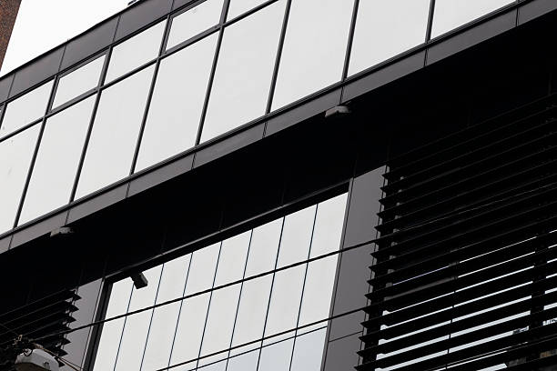 Contemporary building facade showcasing sleek black panels and reflective glass, emphasizing modern architecture and design aesthetics.