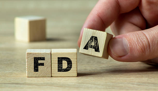 istock Hand assembling wooden blocks with the letters FDA, symbolizing regulatory frameworks in healthcare and food safety. Focus on precision and clarity. 2208633759