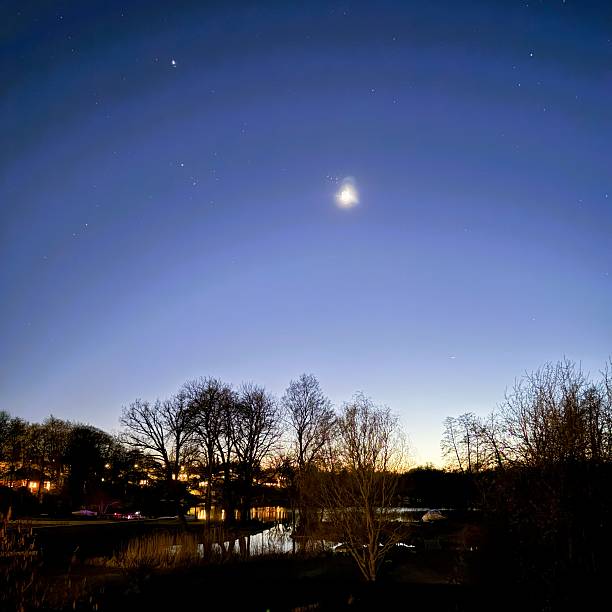 istock Venus and Starry Night Sky Over Lakeside Residential District with Reflections 2208635459