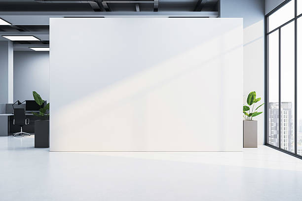 istock Modern office interior with large blank white wall for poster or logo mockup near windows and sunlight casting shadows on the floor. 3D Rendering 2208636001